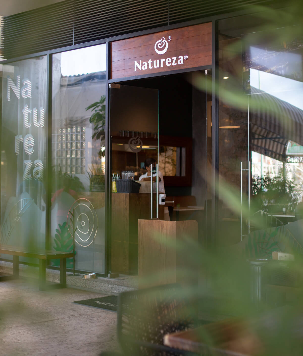 La entrada al Restaurante Natureza en Marina Vallarta con una puerta de vidrio.